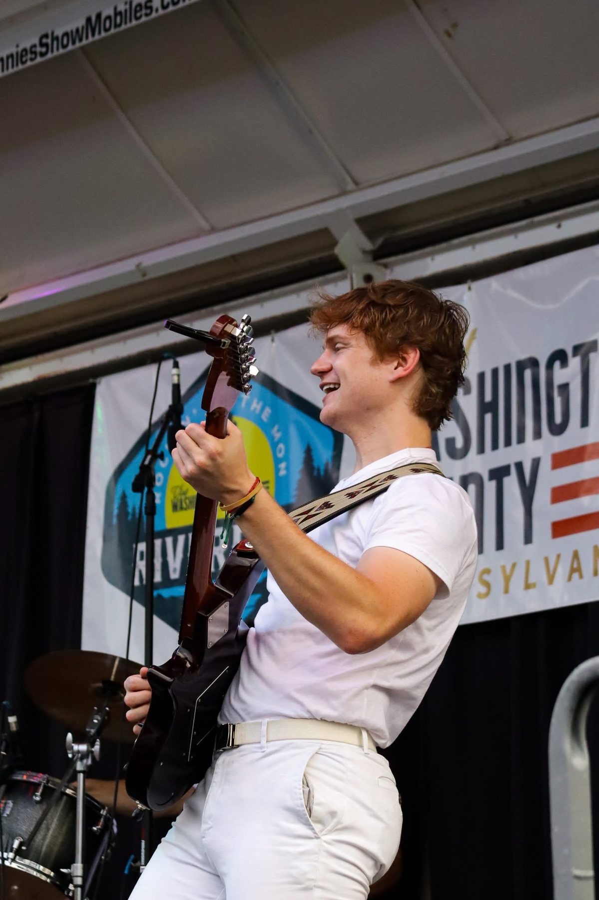 Late Noper playing electric guitar on an outdoor stage