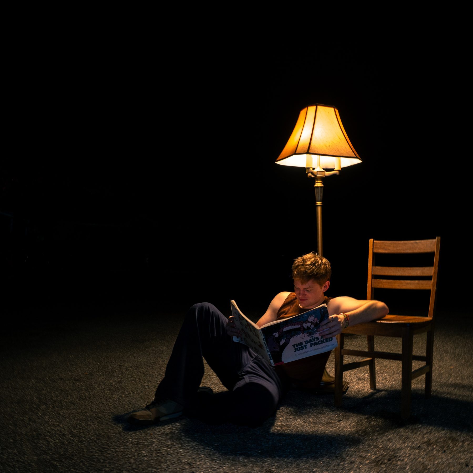 Late Noper reading a Calvin and Hobbes book under a lamp